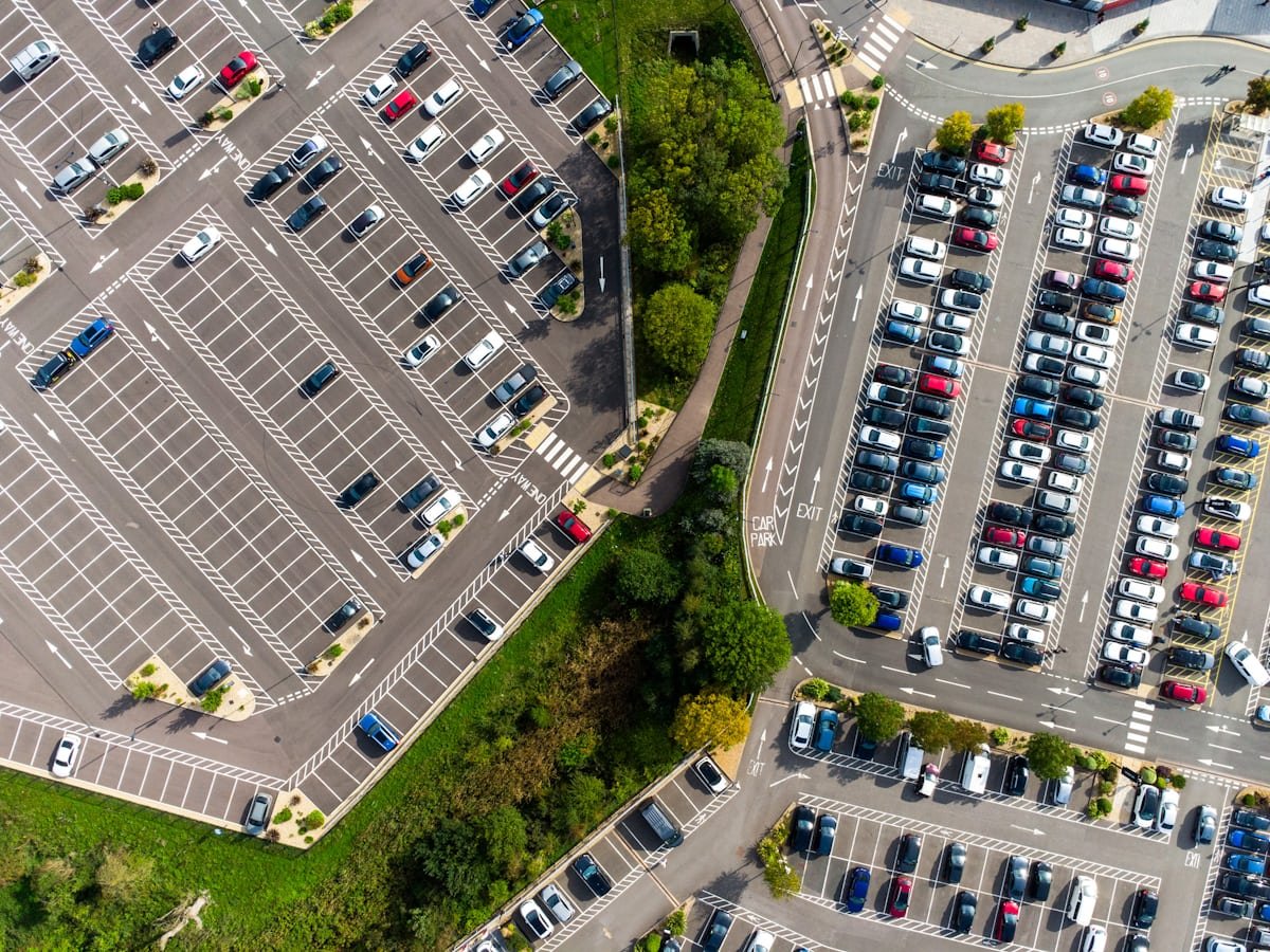 Aerial view of a large parking lot with rows of vehicles