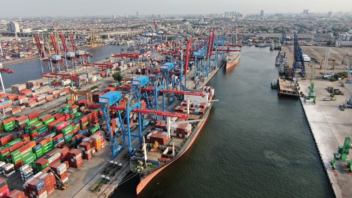 Container ship loading at a busy cargo port with gantry cranes